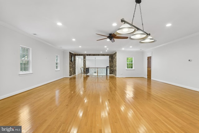 unfurnished living room with light wood-type flooring, ceiling fan, and crown molding