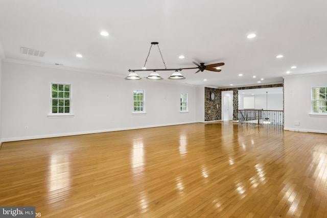 unfurnished living room featuring visible vents, crown molding, a ceiling fan, and light wood finished floors