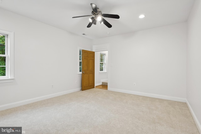 carpeted spare room featuring ceiling fan