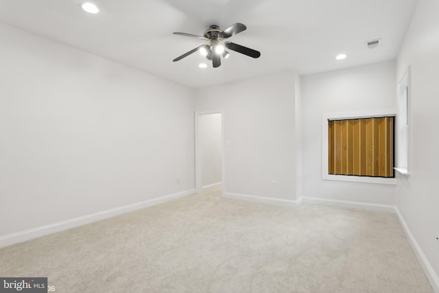 carpeted spare room featuring ceiling fan