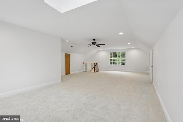 bonus room featuring ceiling fan, light colored carpet, and lofted ceiling with skylight