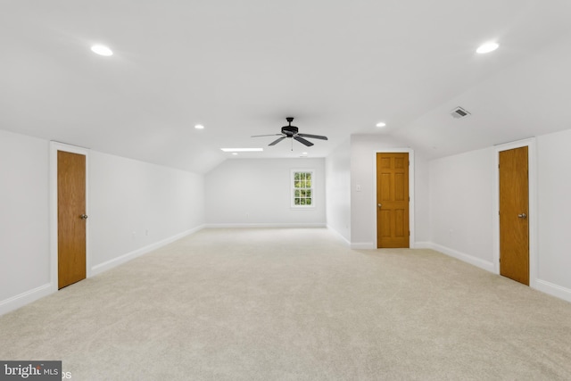 spare room featuring ceiling fan, light colored carpet, and lofted ceiling