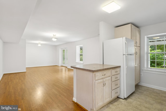 kitchen with light hardwood / wood-style floors, white refrigerator, and light brown cabinetry