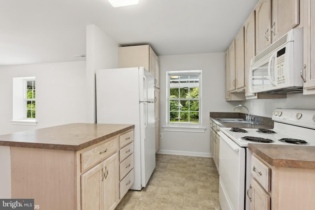 kitchen with white appliances, light brown cabinets, plenty of natural light, and sink