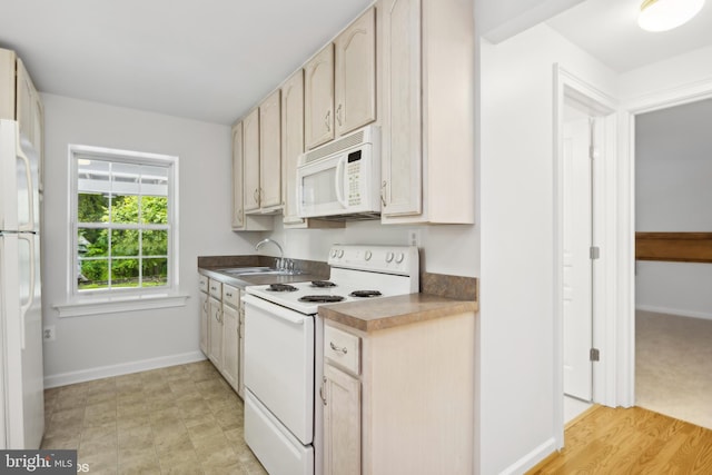 kitchen featuring light brown cabinetry, light wood-type flooring, sink, and white appliances