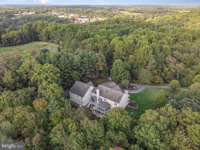 birds eye view of property with a view of trees