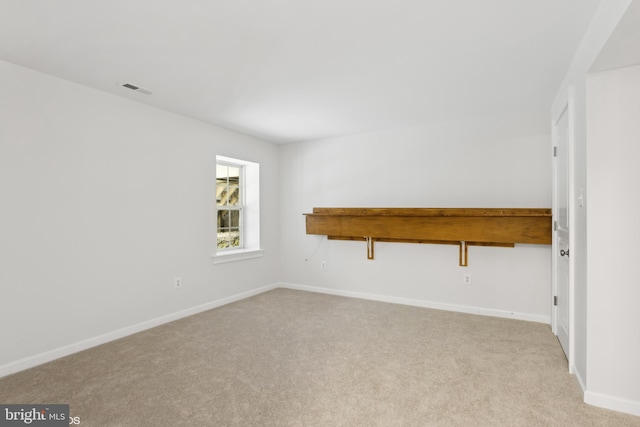 unfurnished room with baseboards, visible vents, and light carpet