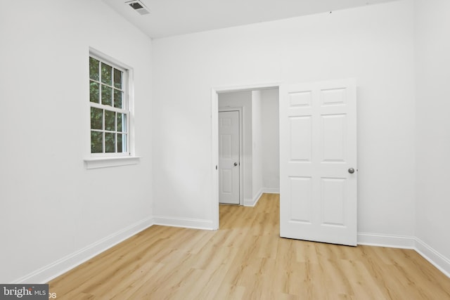 unfurnished room with light wood finished floors, baseboards, and visible vents