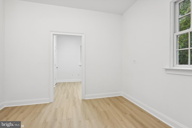 empty room featuring baseboards and light wood-type flooring