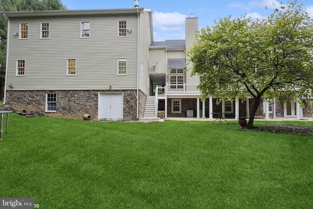 back of house with a lawn and a patio area