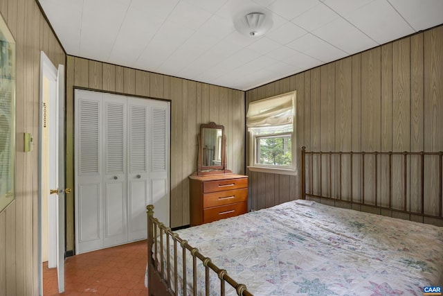 bedroom featuring wood walls and a closet