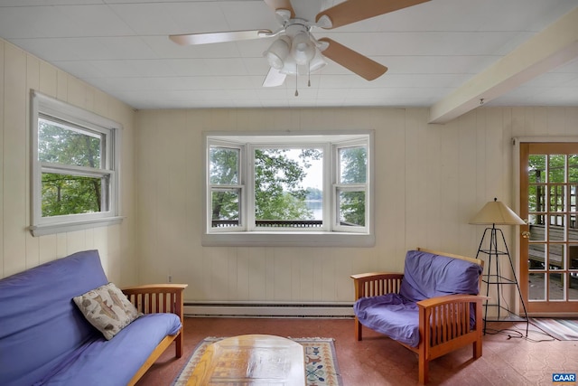 living area with ceiling fan, a baseboard radiator, beam ceiling, and wood-type flooring