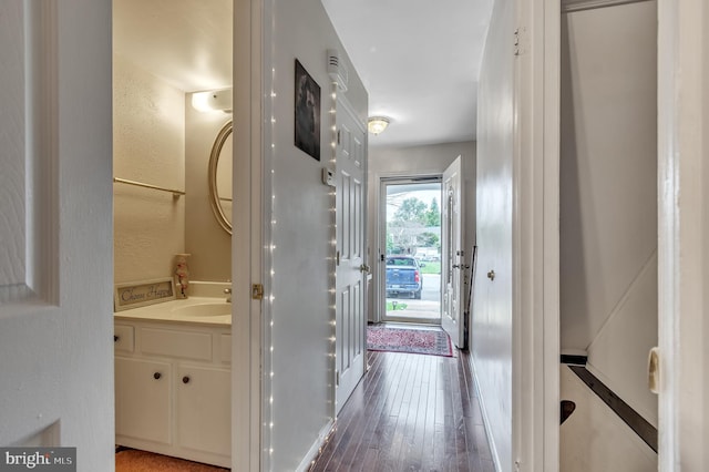 hallway with dark wood-type flooring and sink