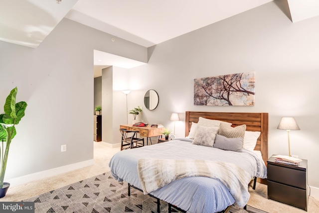 bedroom featuring vaulted ceiling and light colored carpet