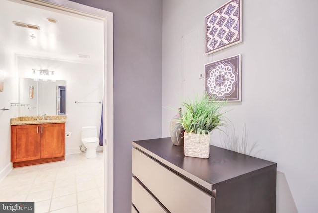 bathroom featuring toilet, vanity, and tile patterned floors