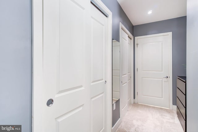 hallway featuring light colored carpet