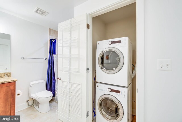 clothes washing area with stacked washer and clothes dryer