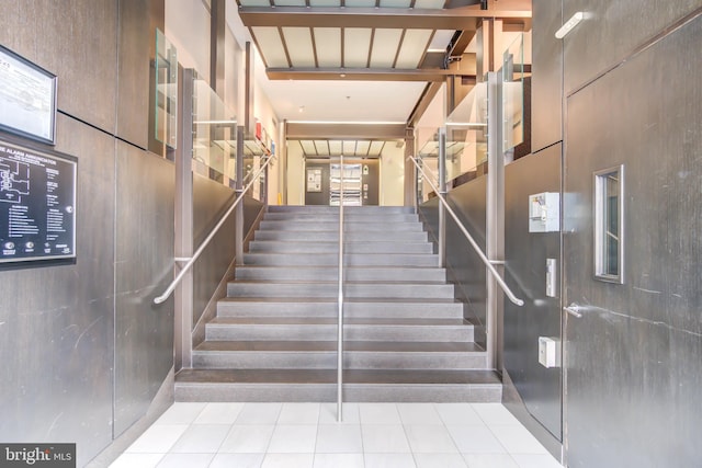 stairway featuring a towering ceiling