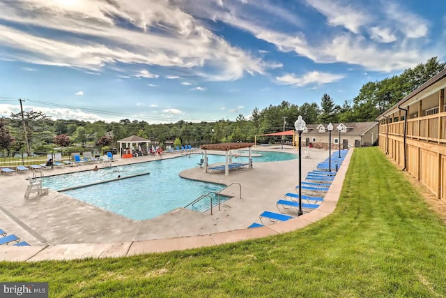 view of pool with a patio and a yard