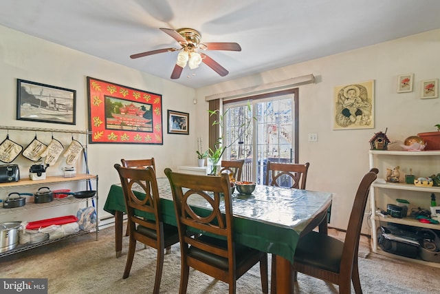 dining space featuring carpet flooring and ceiling fan