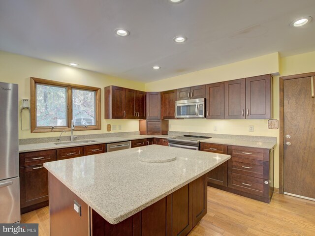 kitchen with recessed lighting, light wood-style flooring, appliances with stainless steel finishes, and a sink