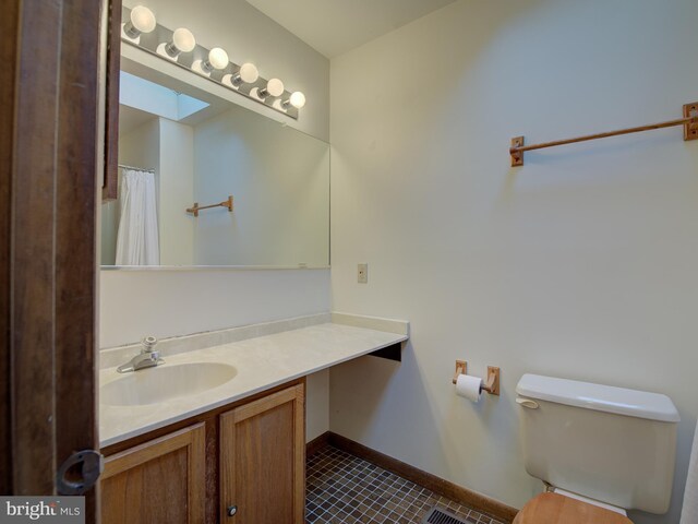 full bathroom featuring visible vents, baseboards, toilet, a skylight, and vanity