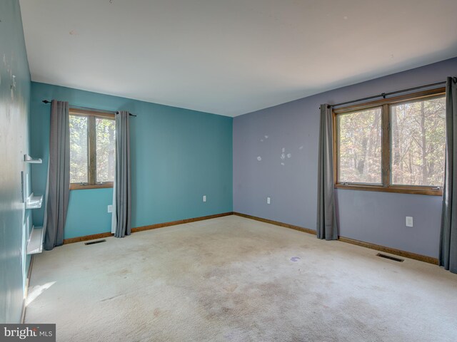 empty room featuring visible vents, baseboards, and carpet floors