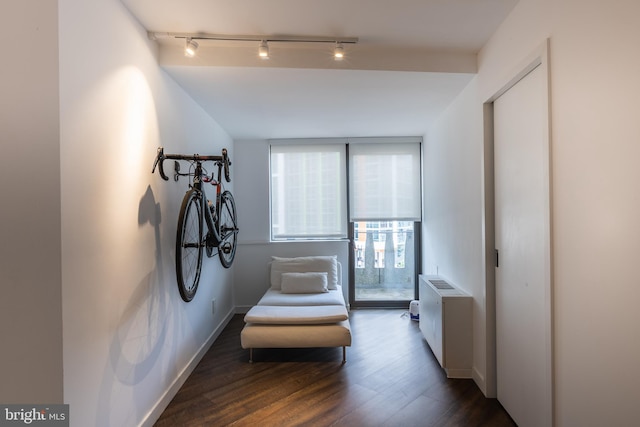 sitting room with radiator heating unit and dark hardwood / wood-style flooring