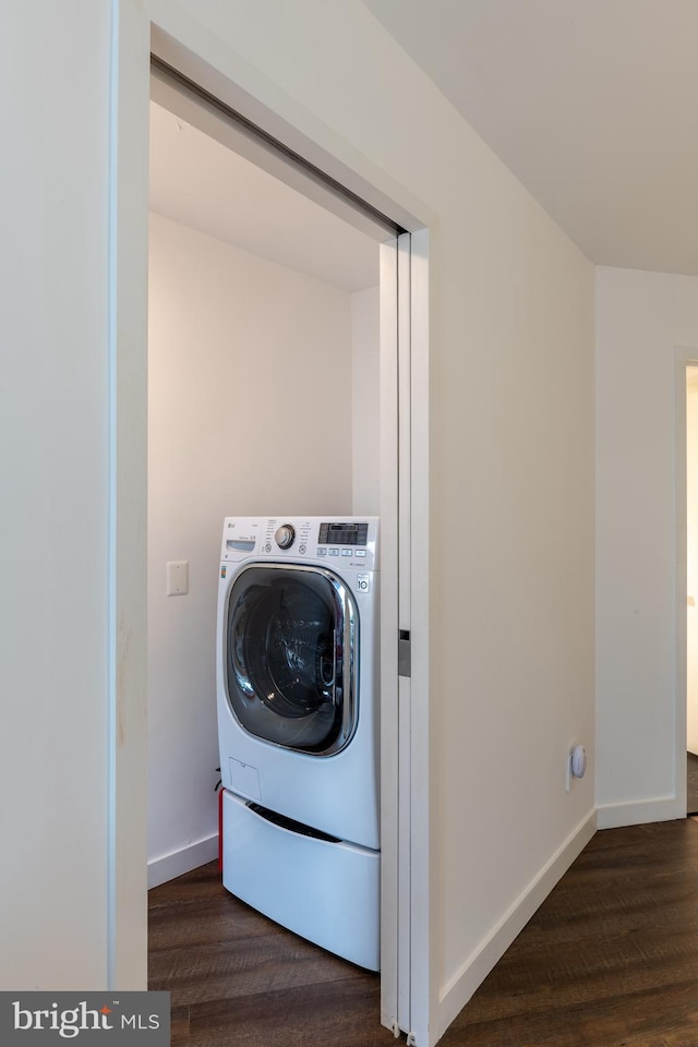 clothes washing area with dark wood-type flooring and washer / clothes dryer