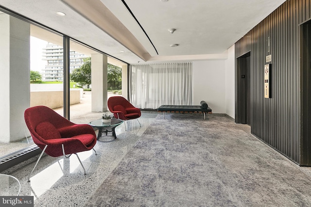 living area with wood walls and floor to ceiling windows