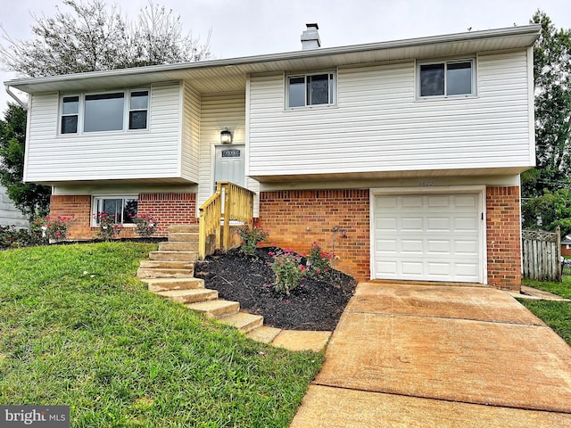 raised ranch featuring a front lawn and a garage