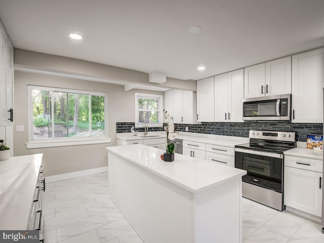 kitchen with a center island, stainless steel appliances, and white cabinets