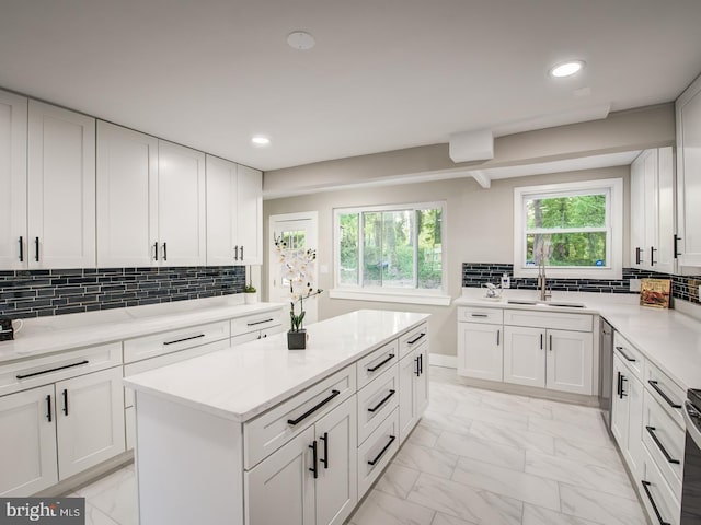 kitchen with white cabinetry, tasteful backsplash, and sink