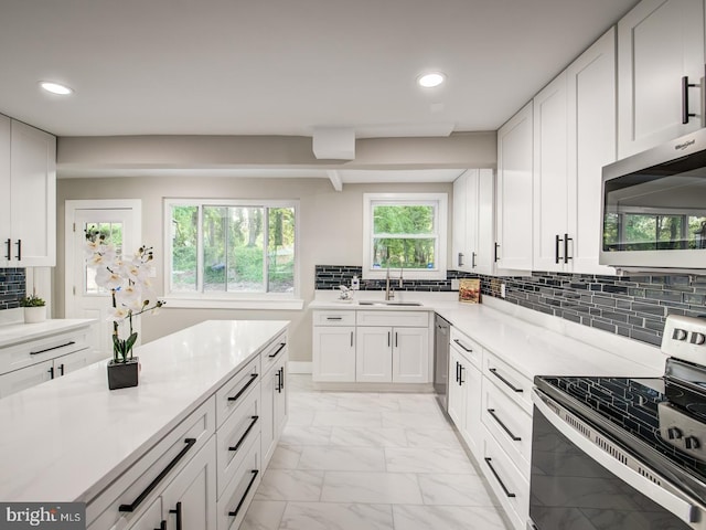 kitchen featuring white cabinets, appliances with stainless steel finishes, and decorative backsplash