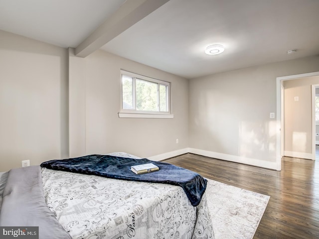 bedroom featuring beam ceiling and dark hardwood / wood-style floors