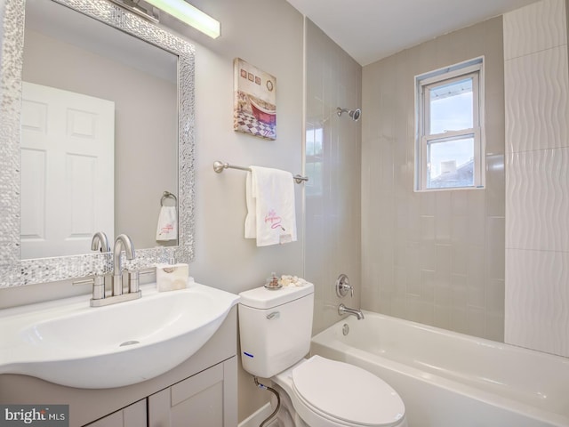 full bathroom featuring tiled shower / bath, vanity, and toilet