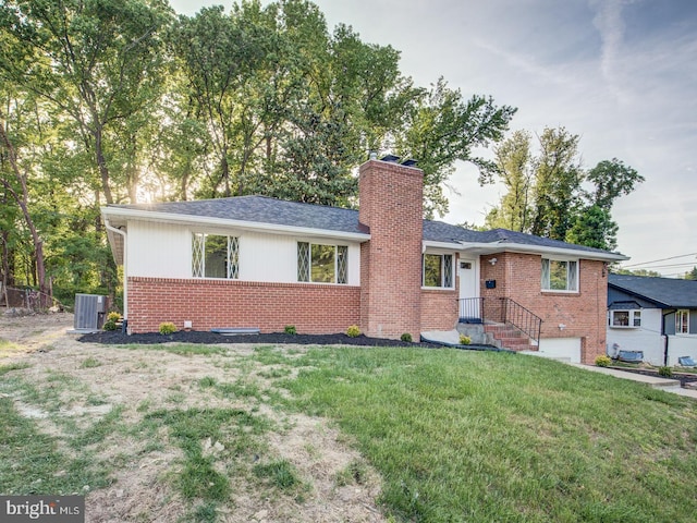 ranch-style home featuring a front lawn and central air condition unit