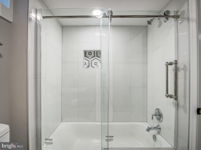 bathroom with tiled shower / bath combo and toilet