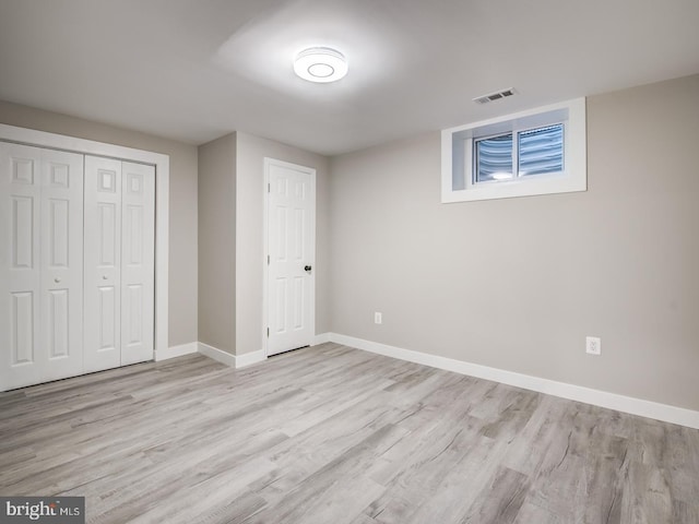 unfurnished bedroom featuring light hardwood / wood-style flooring and a closet