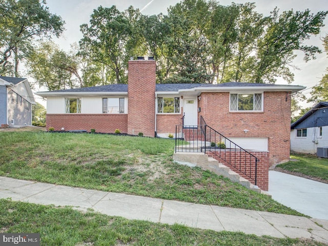 view of front of house featuring central AC unit, a garage, and a front lawn