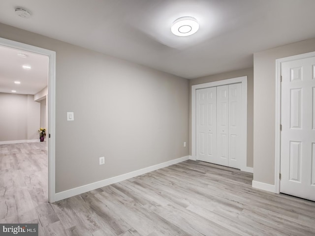 unfurnished bedroom with light wood-type flooring and a closet