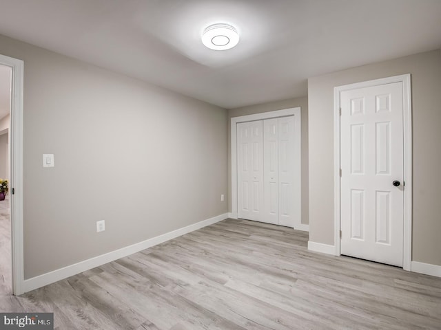 unfurnished bedroom featuring light hardwood / wood-style flooring and a closet