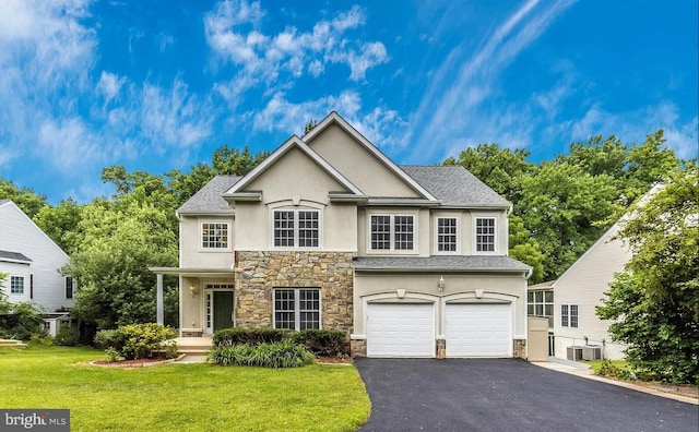 view of front of property with a garage, central AC, and a front yard