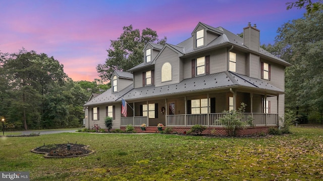 view of front of property featuring a lawn and covered porch