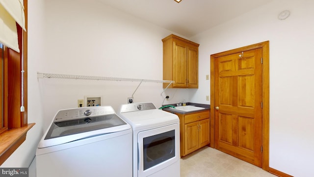 laundry area with sink, independent washer and dryer, and cabinets