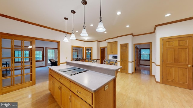 kitchen with light hardwood / wood-style floors, decorative light fixtures, a kitchen island, and white electric stovetop