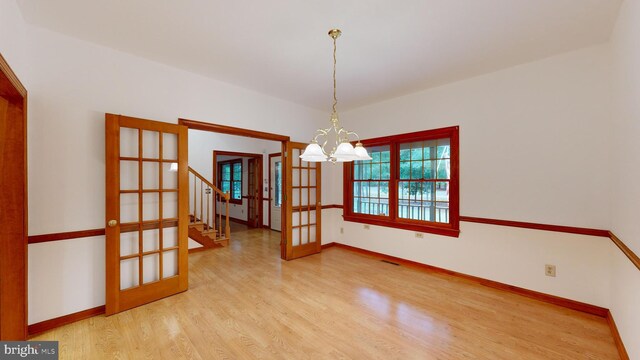 kitchen with pendant lighting, ornamental molding, black appliances, a kitchen breakfast bar, and light wood-type flooring