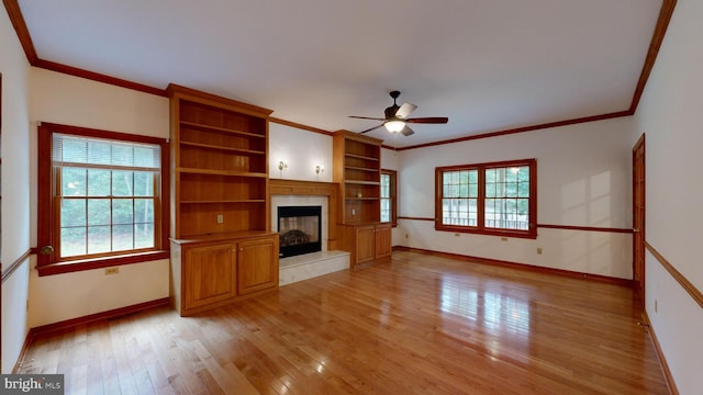 unfurnished living room with light hardwood / wood-style floors, ceiling fan, and crown molding