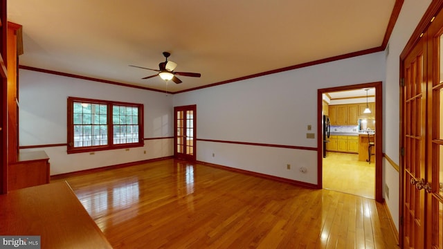 spare room featuring light wood-type flooring, crown molding, and ceiling fan