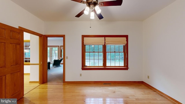 spare room with light wood-type flooring and ceiling fan